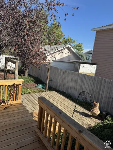 Wood deck with railings and a partial privacy fence