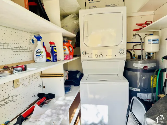 Built-in shelving, pegboard storage, and a stackable washer and dryer unit