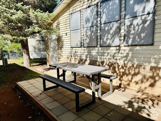 Patio area with paver flooring, siding exterior, and a permanent exterior door