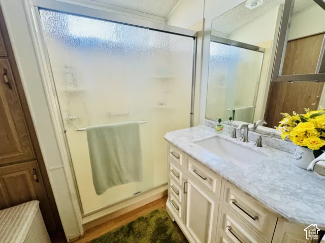White vanity with a stone countertop, an integrated sink, and brushed nickel fixtures