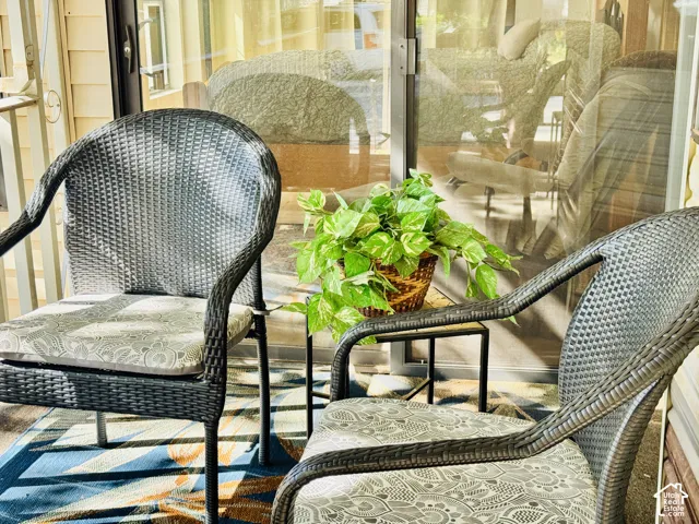 Sliding glass door entry to an outdoor area with siding and a railing