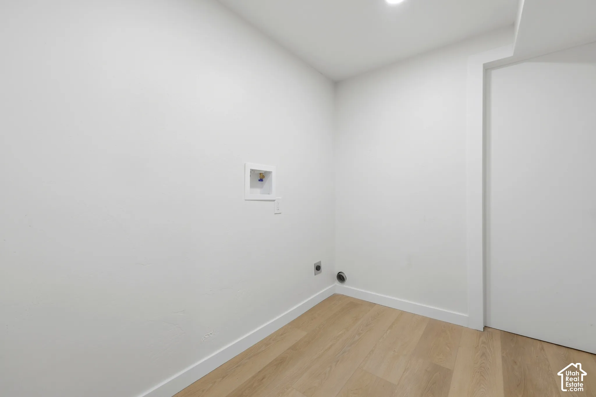 Recessed lighting, wood-finish flooring, white walls, and dedicated laundry hookups