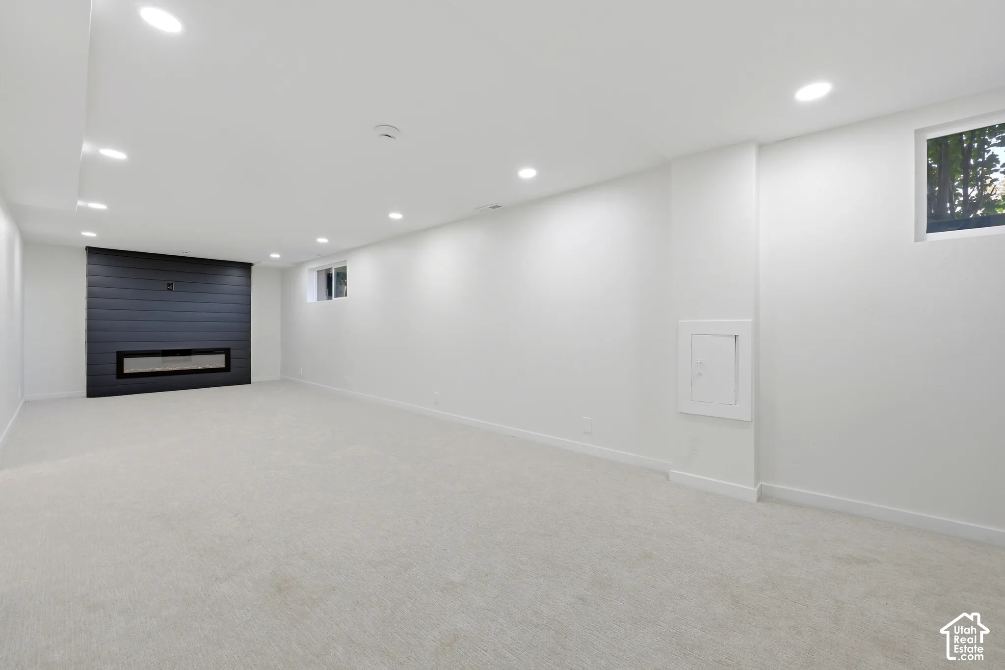 Spacious room featuring light-toned carpeting and recessed lighting