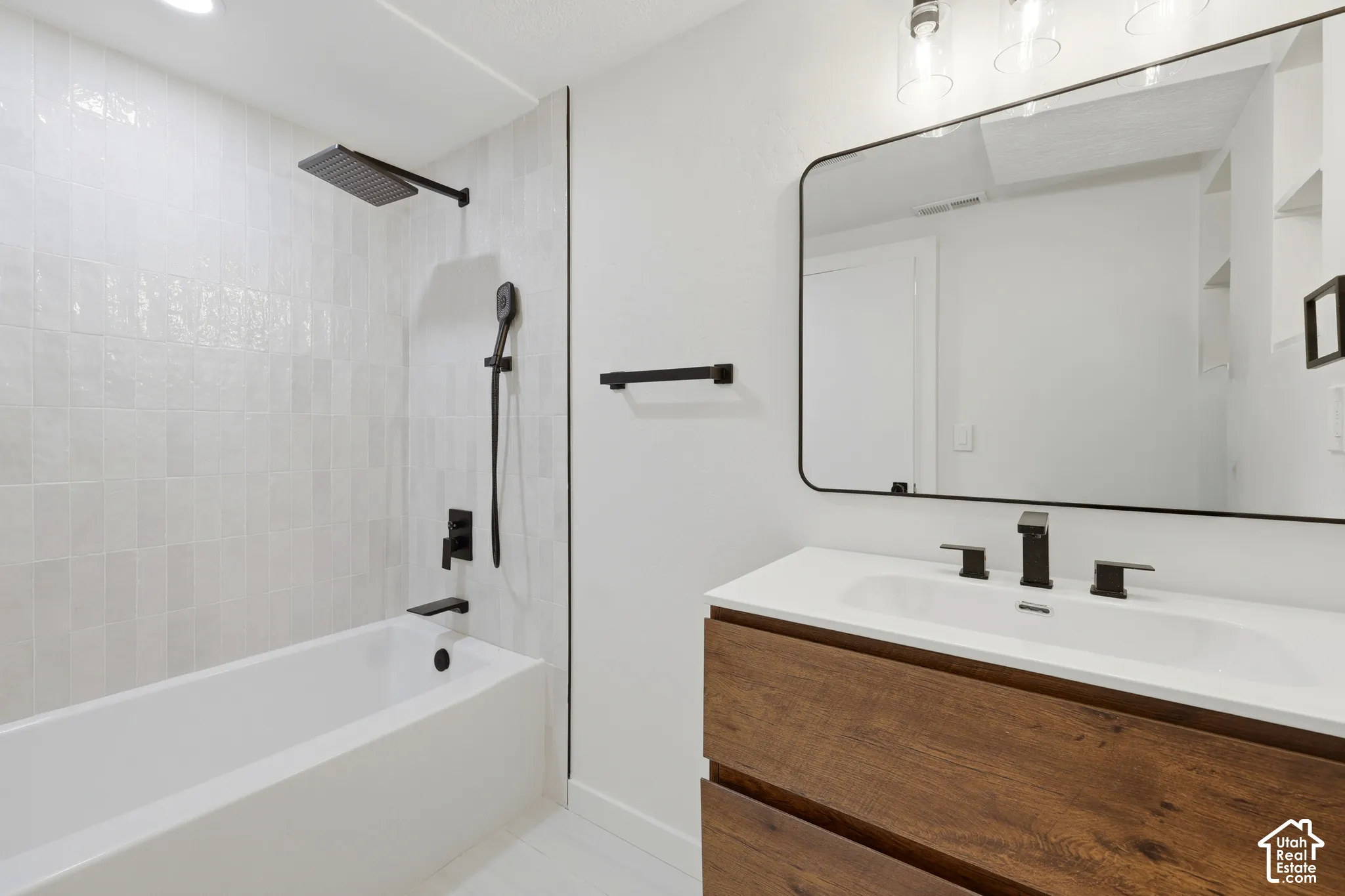 Modern bathroom featuring a wood-finish vanity with a white quartz countertop, dual rectangular vessel sinks, and matte black faucetry