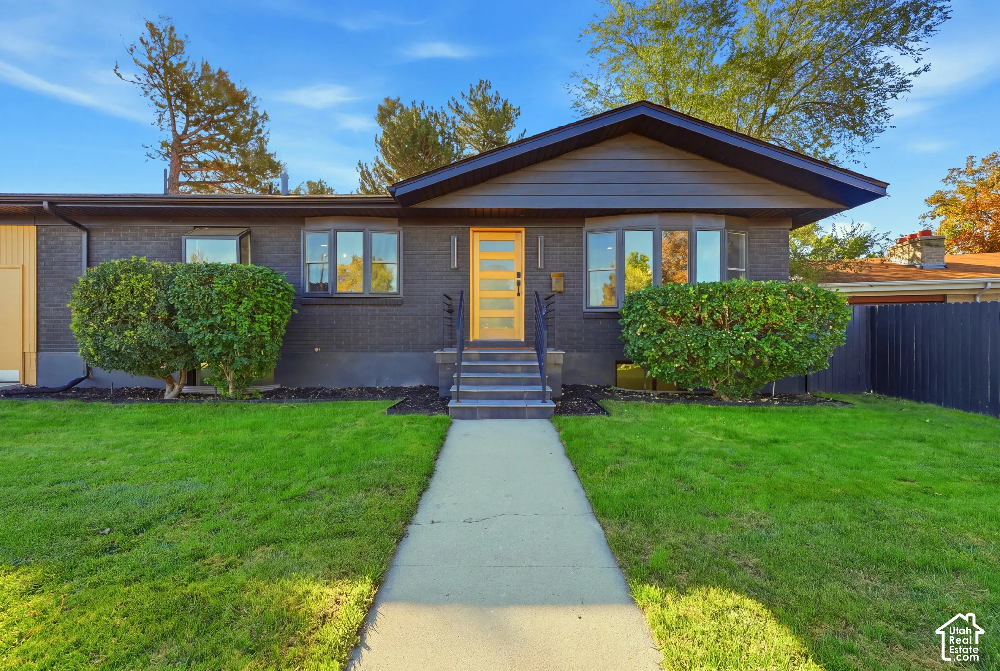 Dark-toned brick exterior with a contrasting yellow front door