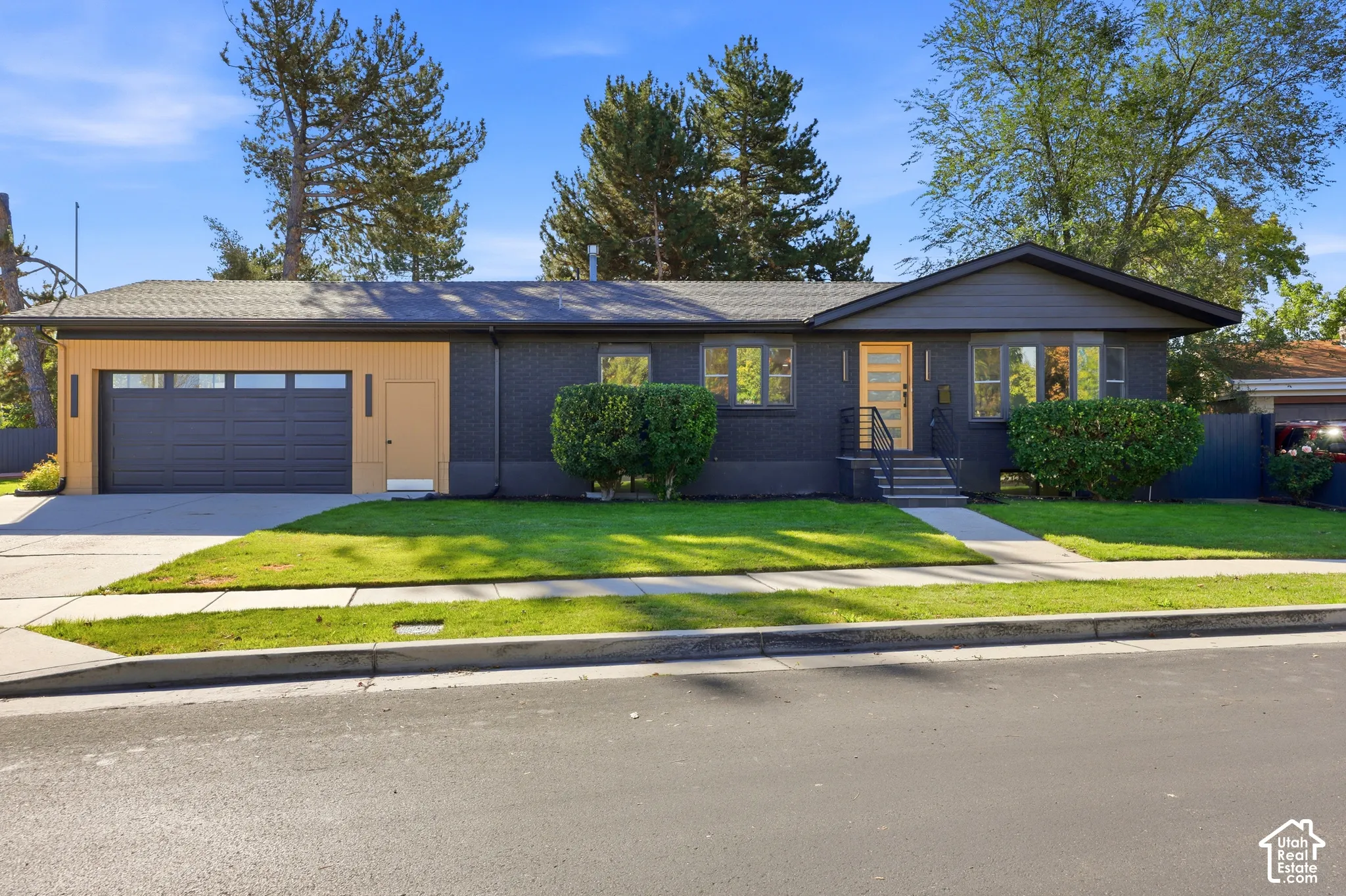 Contemporary ranch-style exterior with dark brick siding and a contrasting light wood-finish accent wall
