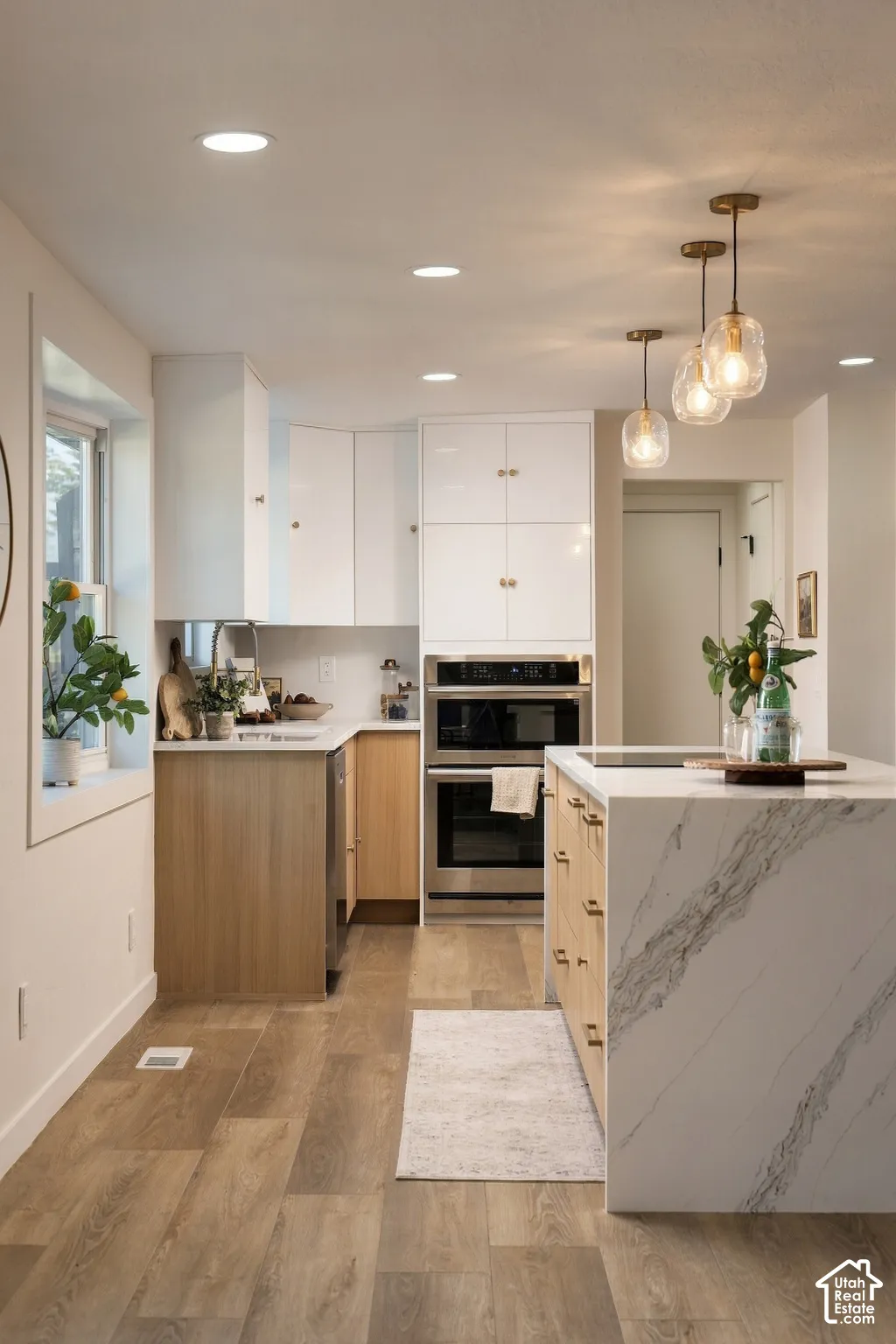 Wood-finish flooring throughout, stainless steel built-in double oven, and recessed lighting