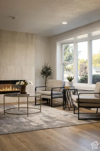 Wood-finish flooring throughout, recessed lighting, and a prominent fireplace with a light-toned stone surround
