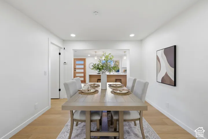 Recessed lighting illuminates the space, featuring wood-finish flooring and a white color palette