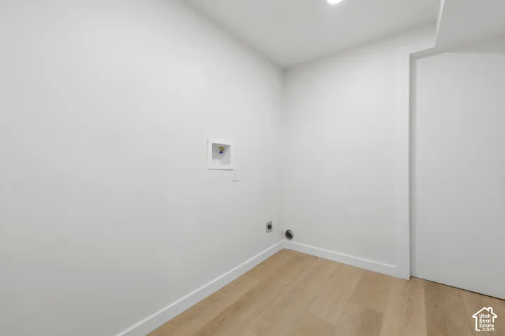 Recessed lighting, wood-finish flooring, white walls, and dedicated laundry hookups