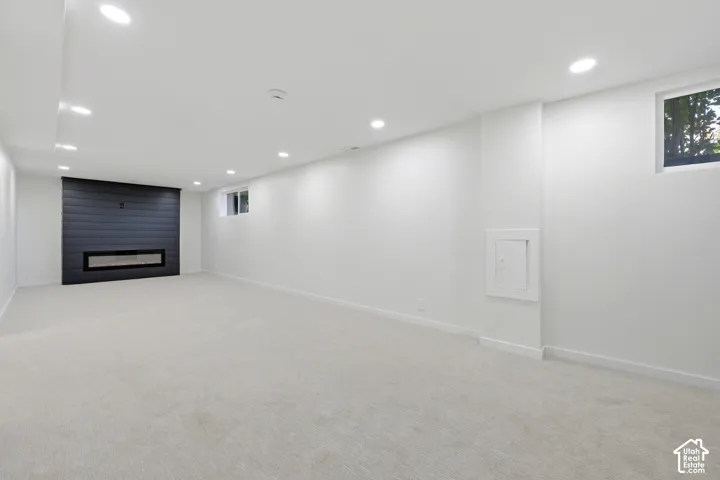 Spacious room featuring light-toned carpeting and recessed lighting