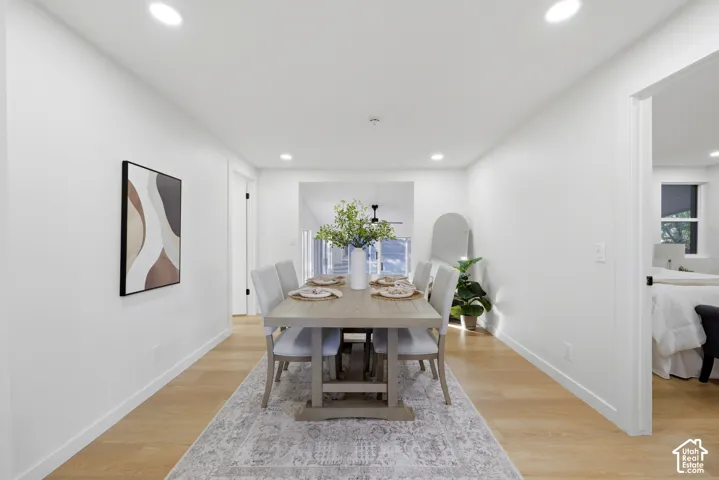 Dining area featuring recessed lighting, wood-finish flooring, a neutral color palette, and an adjacent entryway