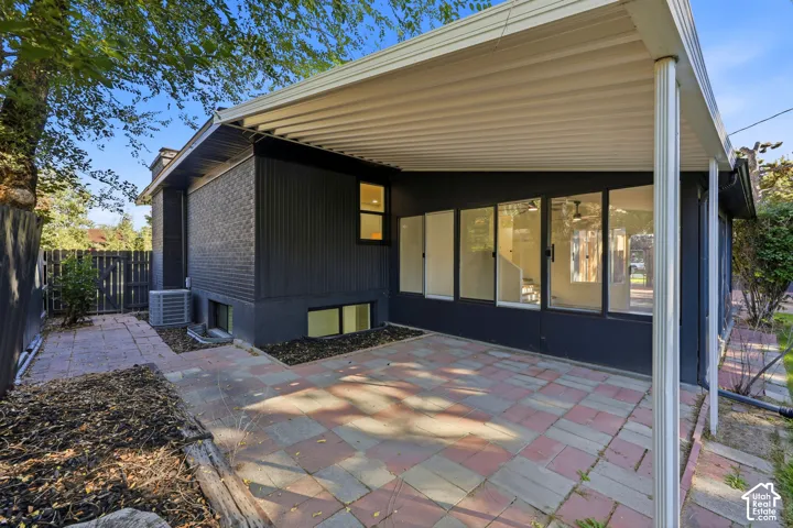 Covered patio with brick paver flooring and multiple large windows