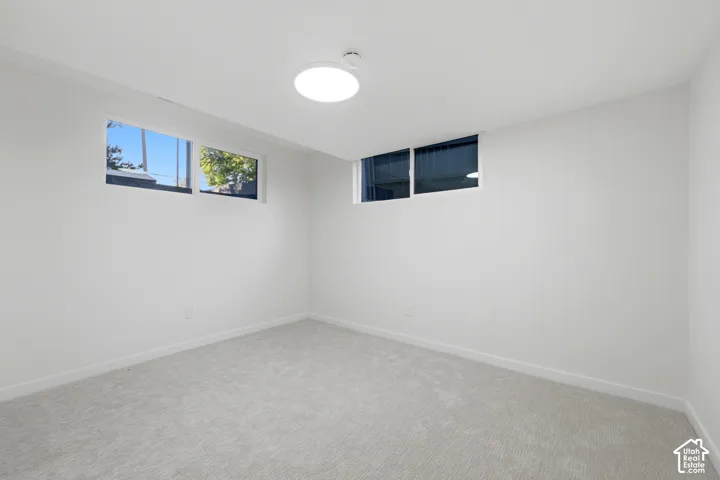 Neutral-toned carpeting paired with white walls, featuring multiple horizontal windows and recessed lighting