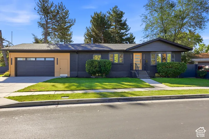 Contemporary ranch-style exterior with dark brick siding and a contrasting light wood-finish accent wall