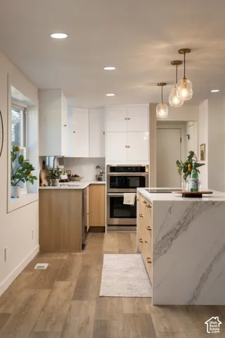 Wood-finish flooring throughout, stainless steel built-in double oven, and recessed lighting