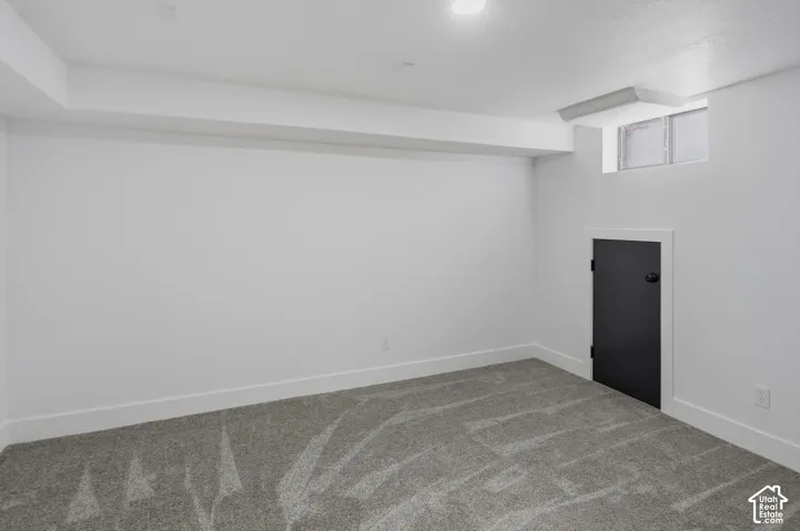 Recessed lighting fixtures, white walls, and gray patterned carpeting