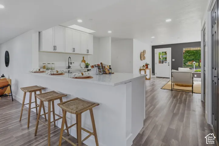 Kitchen bar with white cabinetry and a light-toned countertop