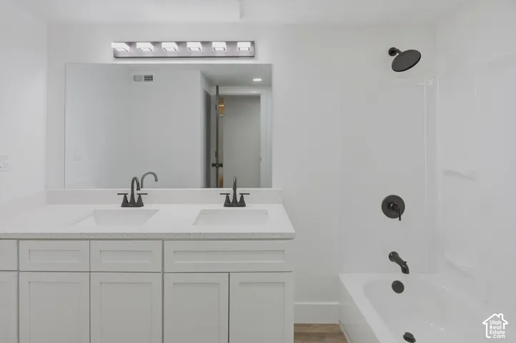 Double vanity with dual undermount sinks, white cabinetry, and a light-toned countertop