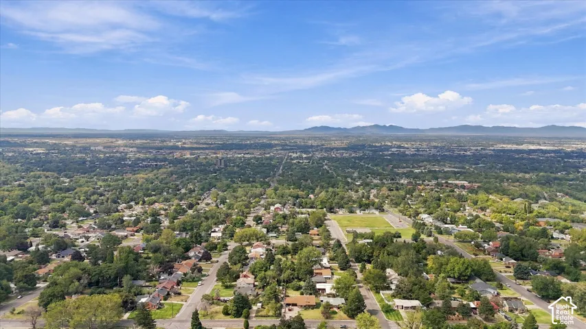 Expansive residential area featuring established homes, mature trees, and mountainous terrain in the distance