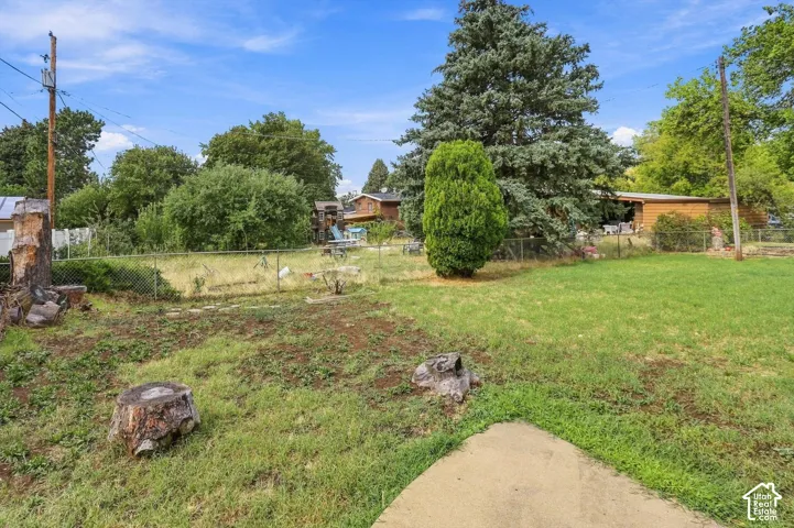 Spacious grounds featuring mature landscaping, established shade trees, and a manicured lawn
