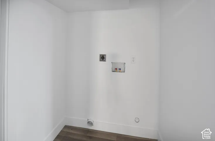 Dedicated laundry area with hookups for appliances, modern wood-finish flooring, and crisp white walls