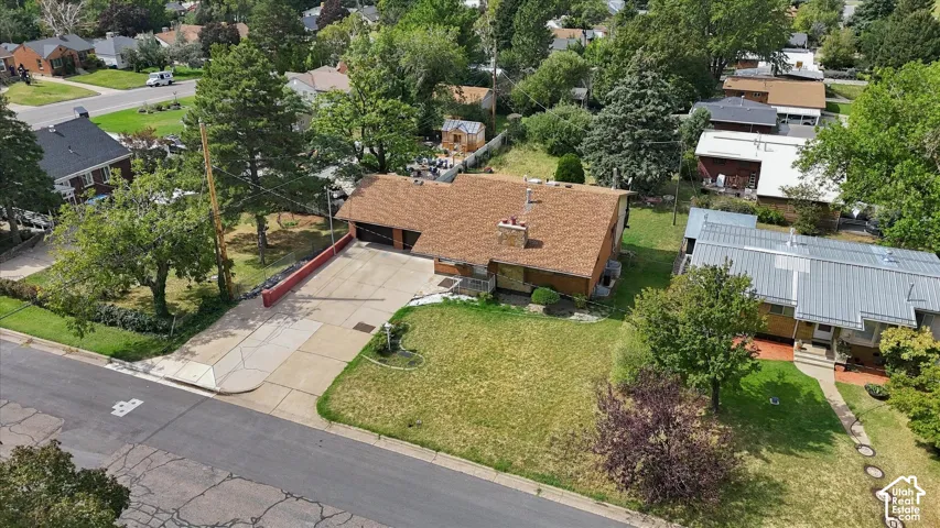 Single-story residence with a brown shingle roof, integrated two-car garage, front lawn, and paved driveway