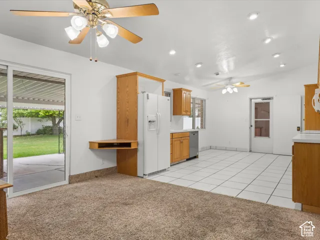 Kitchen featuring wood cabinetry, white tile flooring, recessed lighting, and sliding glass doors to a covered patio