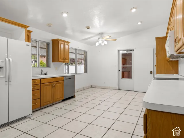 Kitchen featuring natural wood cabinetry, white countertops, recessed ceiling lighting, a ceiling fan, and tiled flooring