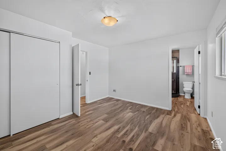 Wood-finish flooring, white walls, and a ceiling-mounted light fixture