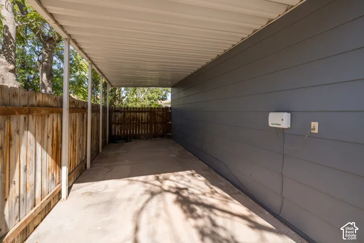 Covered concrete patio with horizontal wood fencing and horizontal siding