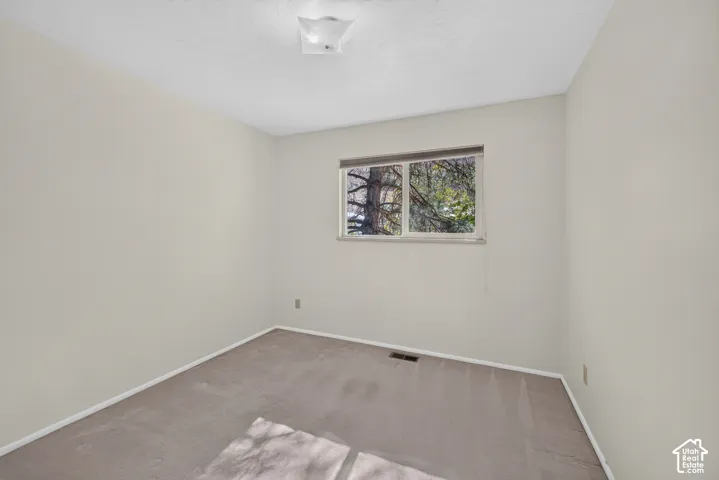 Neutral-toned walls complement the carpeted flooring