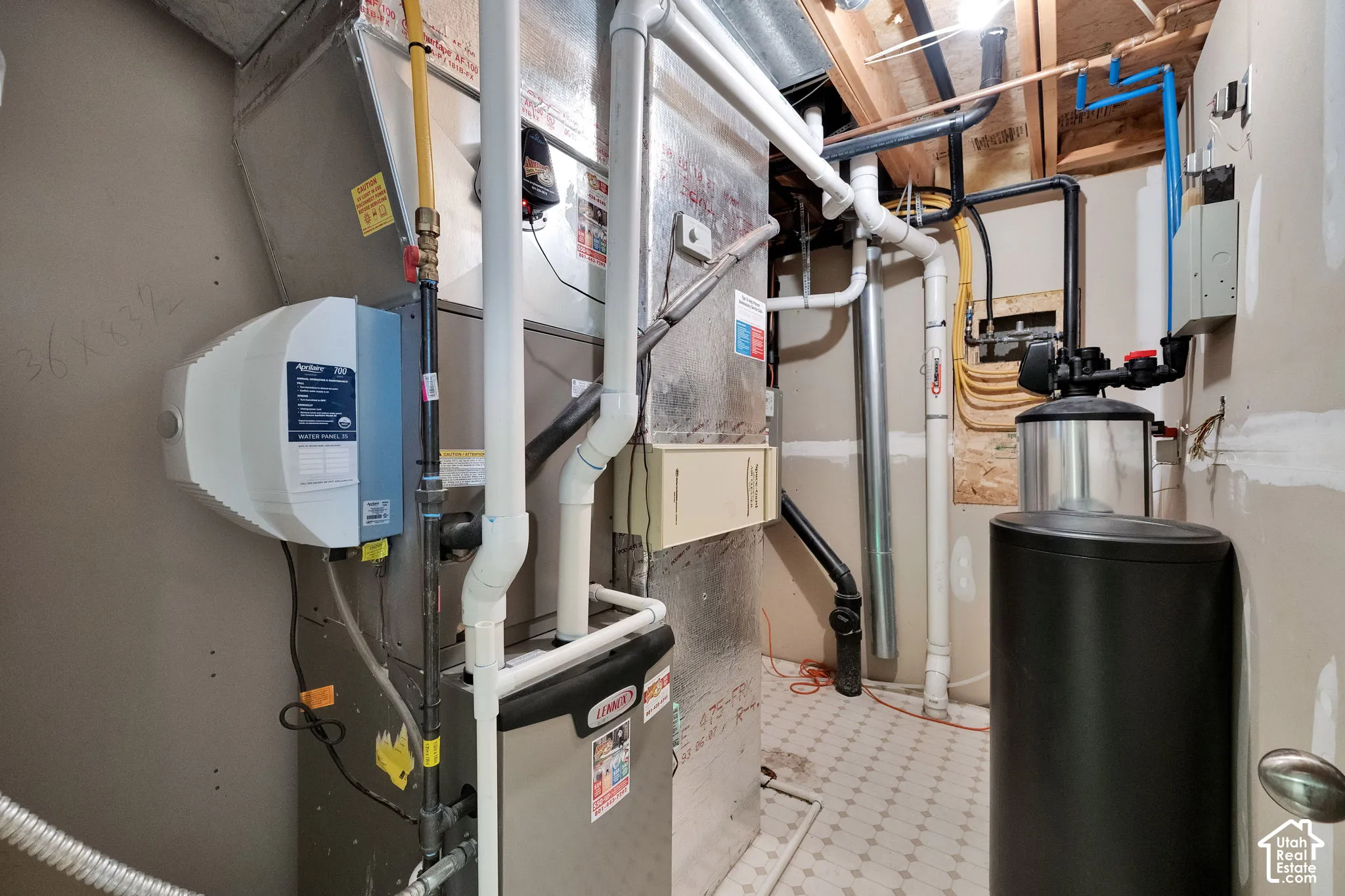 Furnace system featuring a humidifier, water softener, and visible ductwork with radon mitigation system