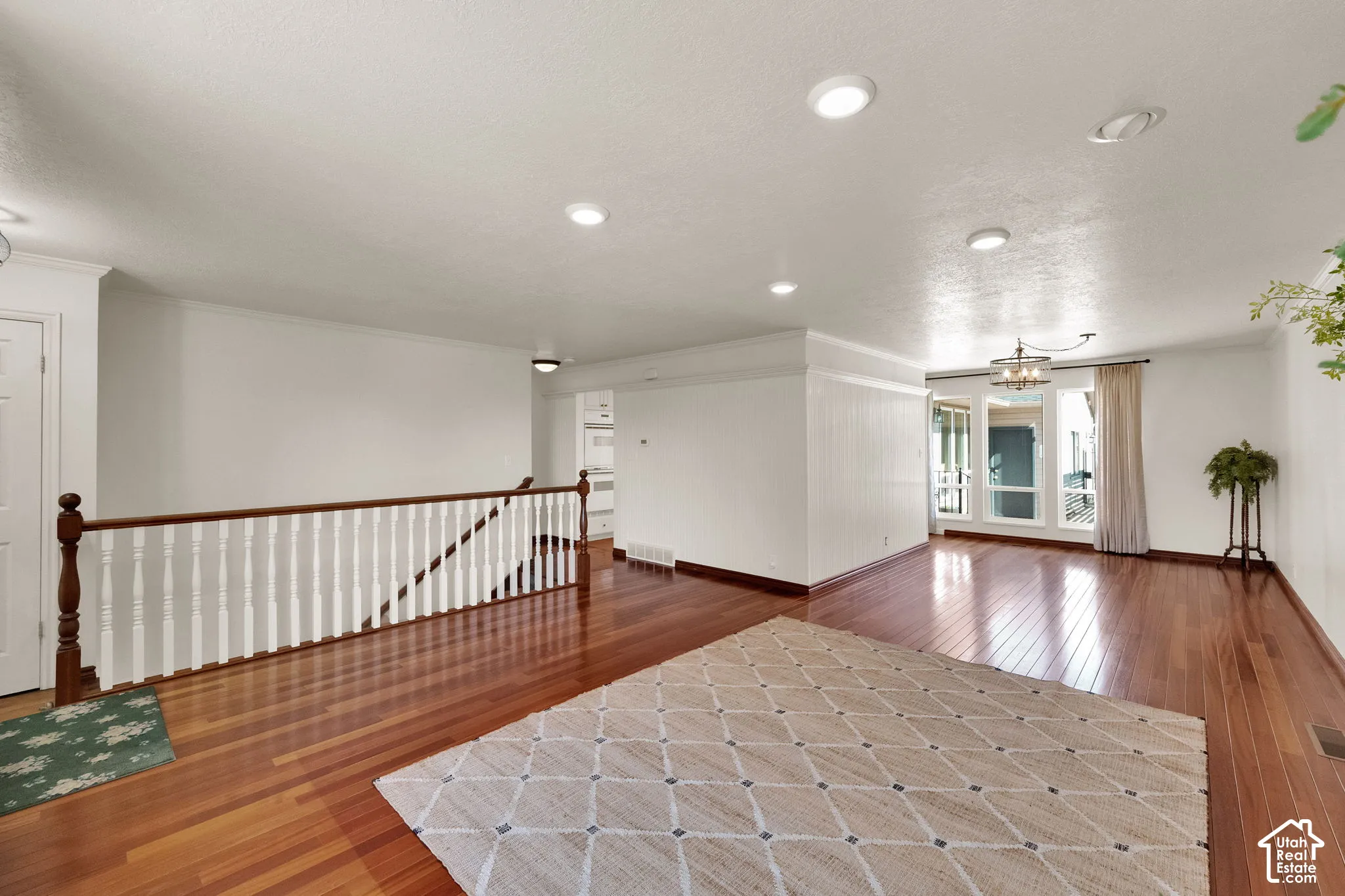 Hardwood flooring, soft light toned walls, and recessed lighting