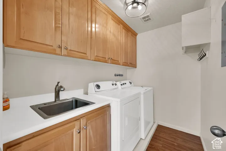 Wood-finish flooring, built-in cabinetry, overhead lighting, integrated sink with faucet, and white countertops