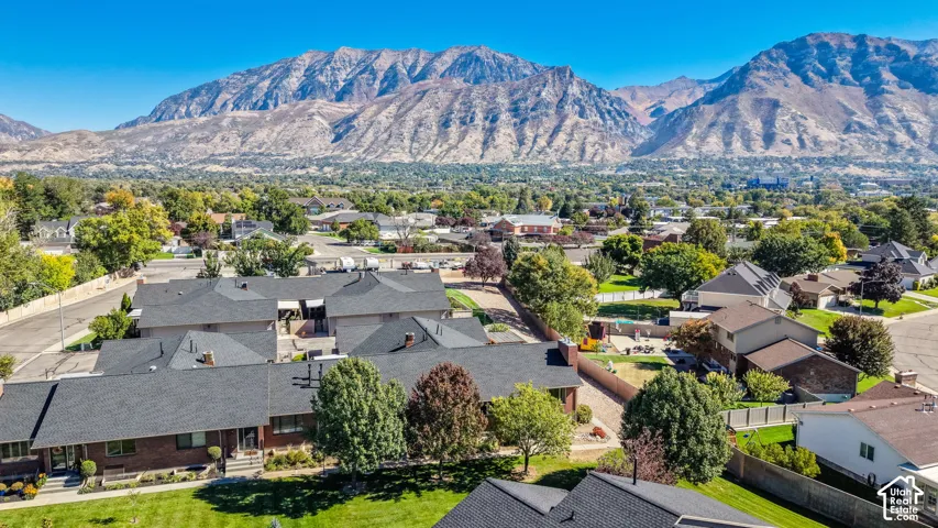 Residential neighborhood with mature trees and a prominent mountain backdrop