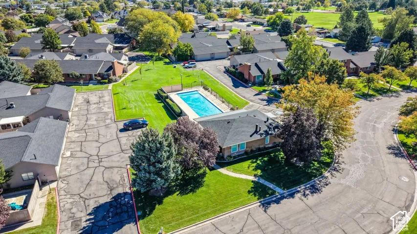 Community swimming pool, expansive green spaces, mature trees, and residential buildings