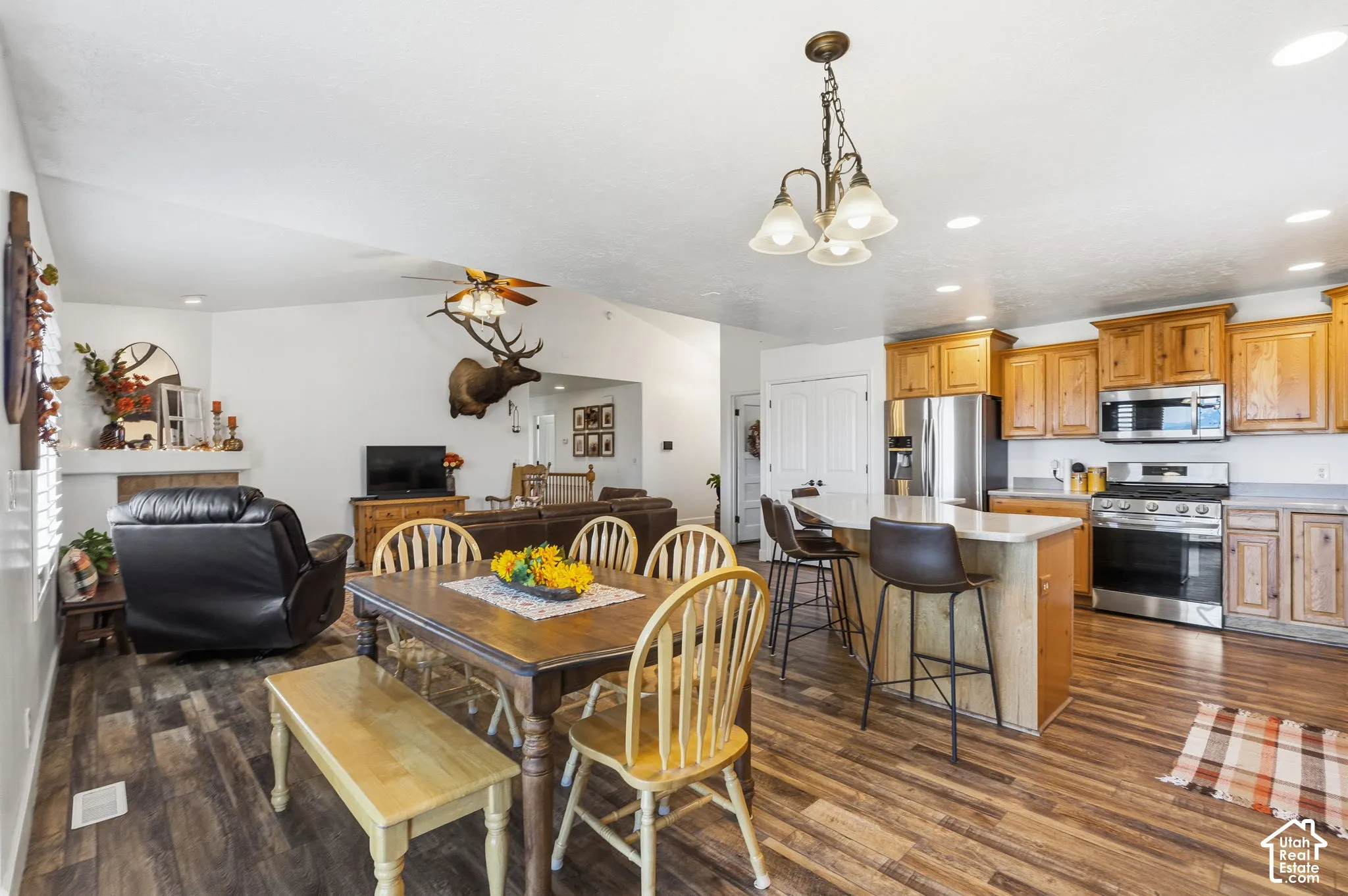 Spacious kitchen featuring stainless steel appliances, light wood-finish cabinetry, and a kitchen island with seating