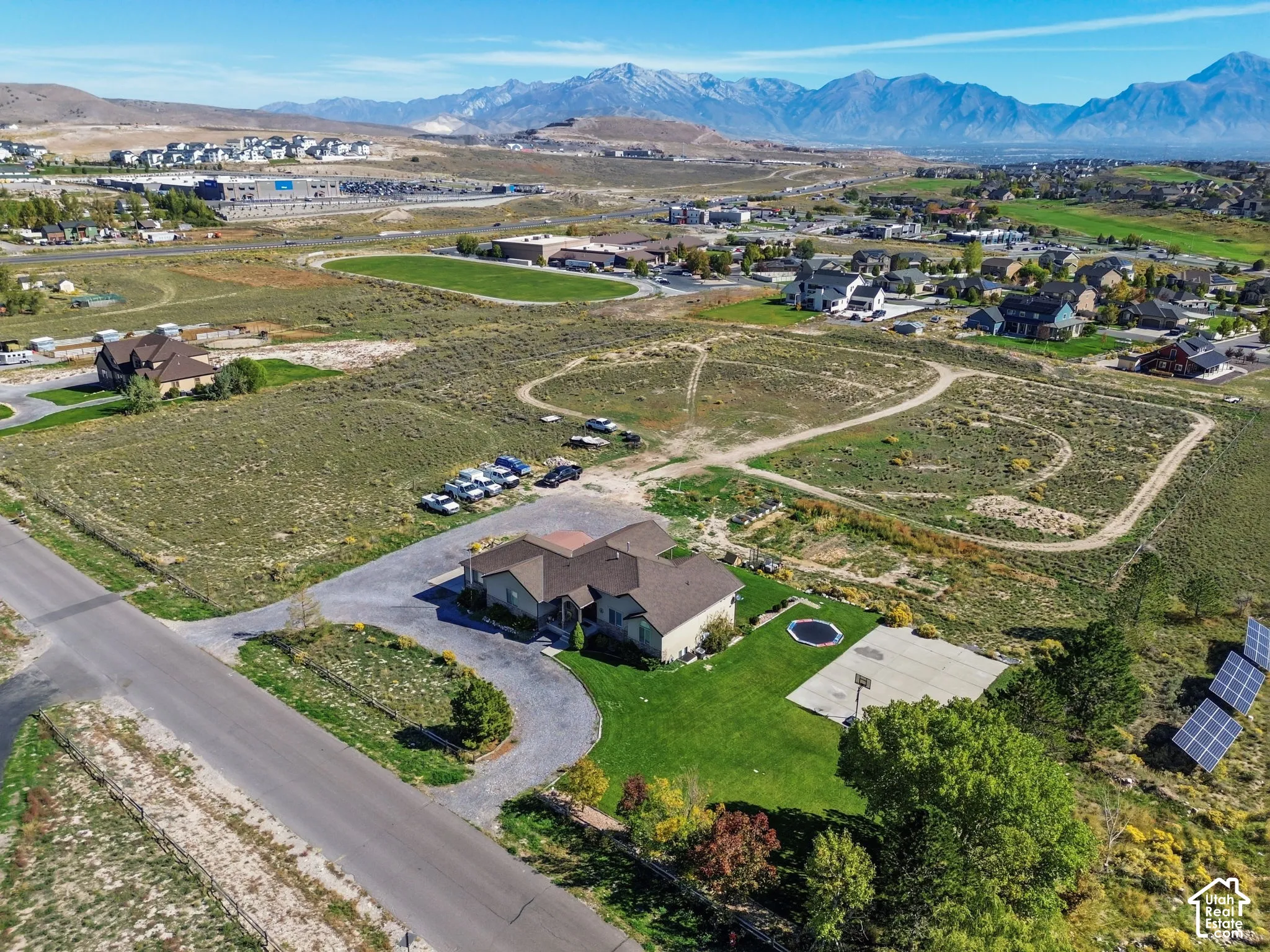 Expansive property featuring a circular driveway, a basketball court, and solar panels
