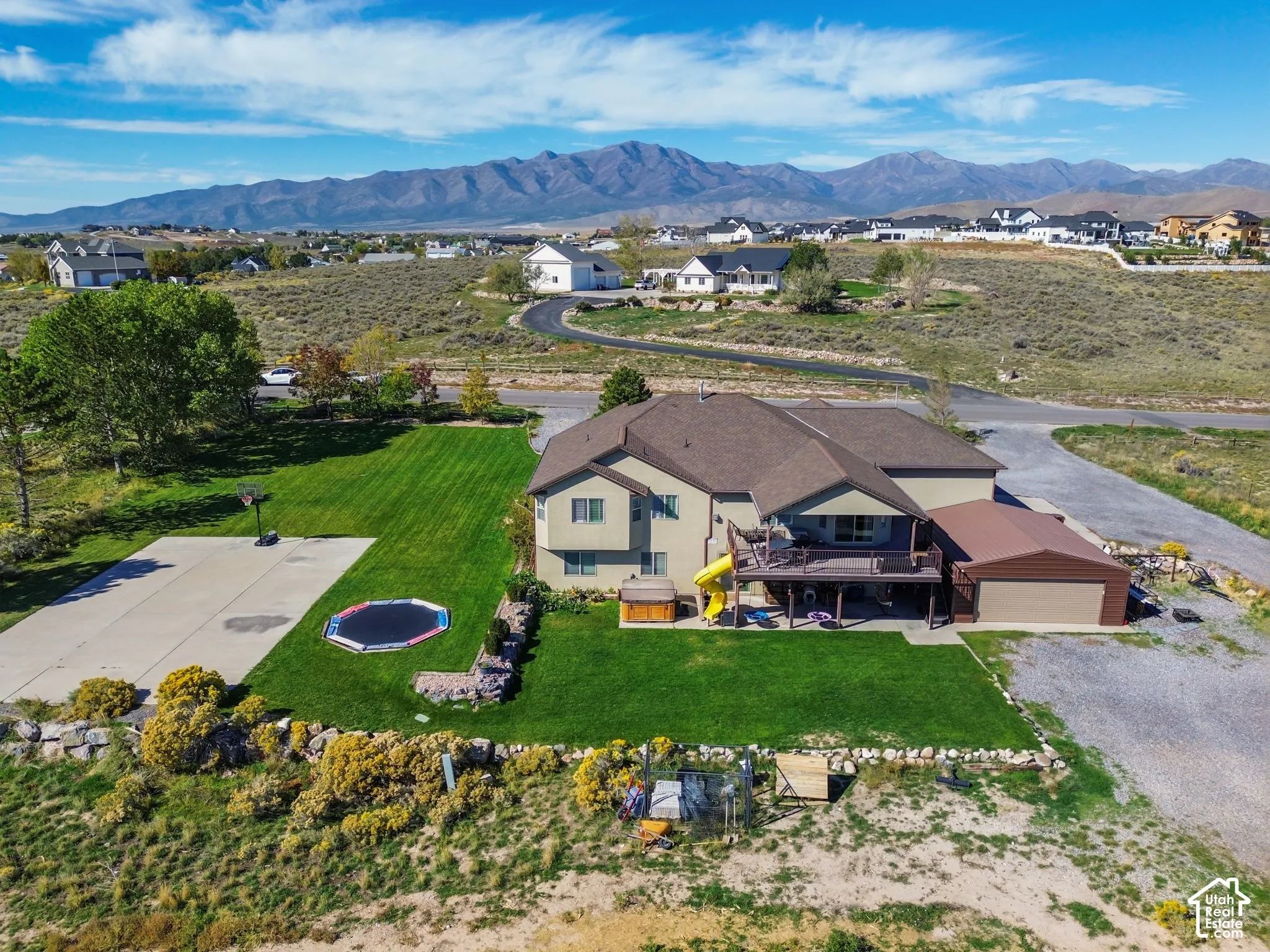 Expansive lawn with a concrete sports court and a multi-level deck