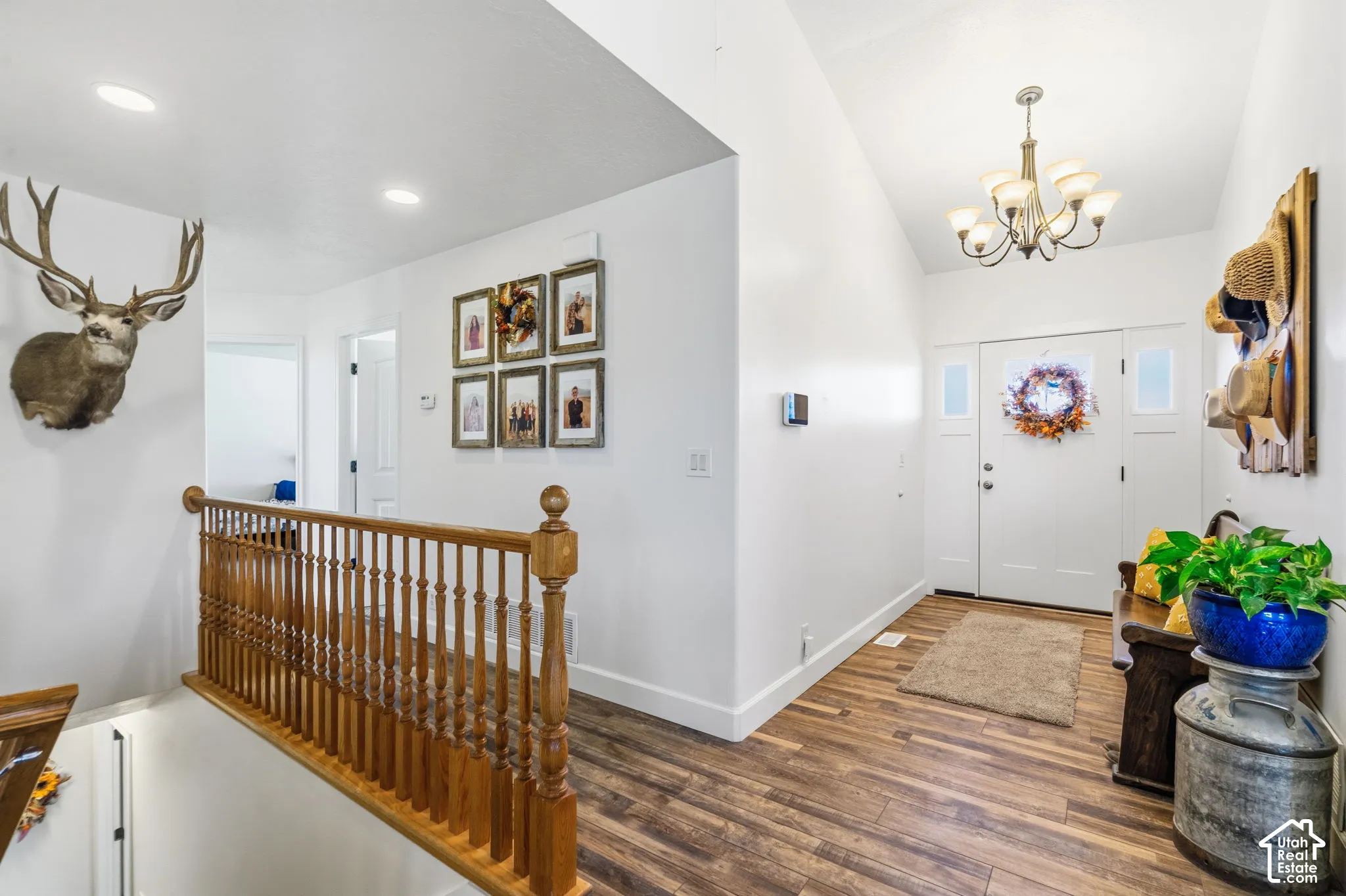 Wood-finish flooring, white walls, and a wood banister