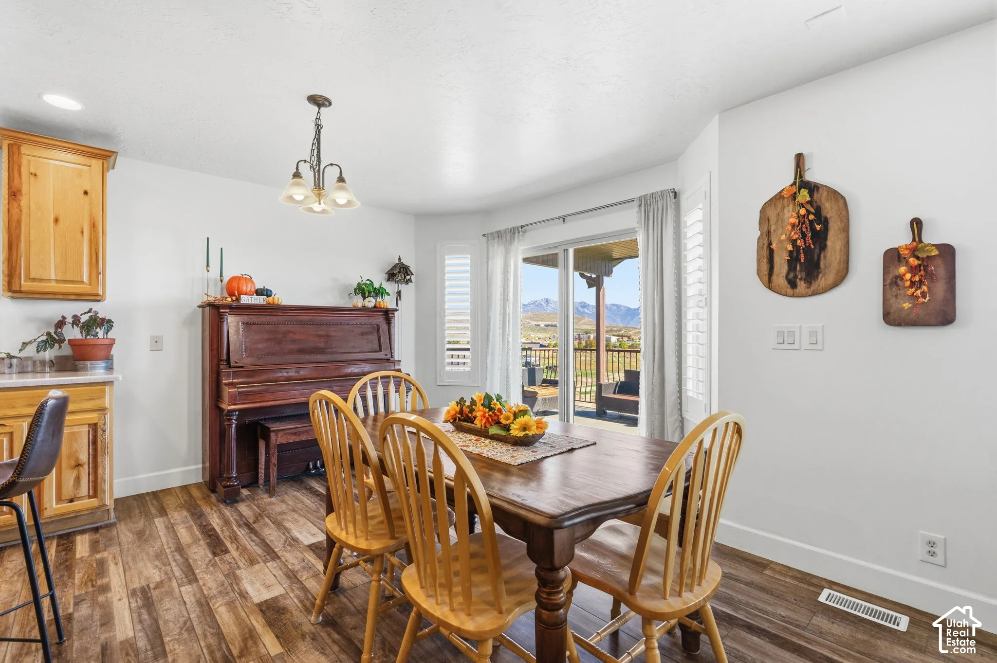 Wood-finish flooring, recessed lighting, and a chandelier with frosted glass shades