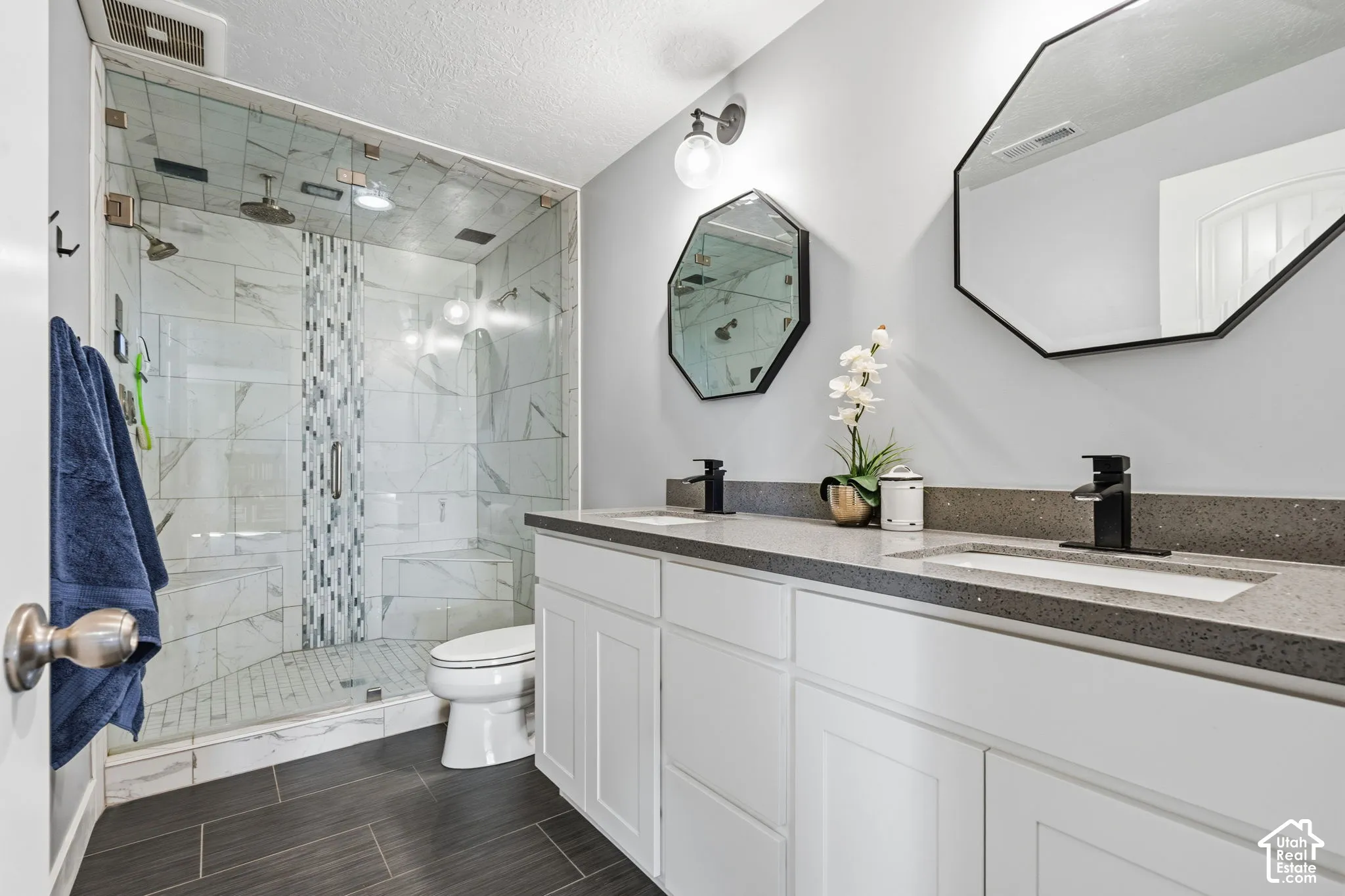 Double vanity with integrated sinks and black fixtures, featuring a light grey countertop