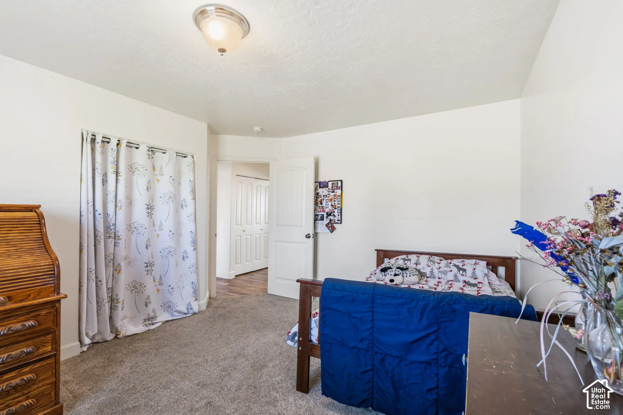 White walls complement the gray carpet flooring and semi-flush mount ceiling light