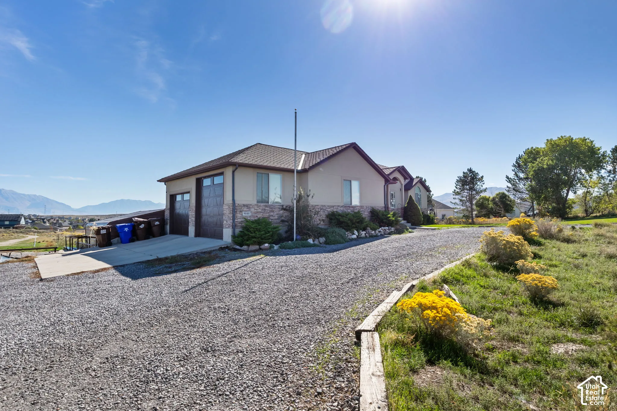 Exterior featuring a two-car garage, stucco siding, and stone accents