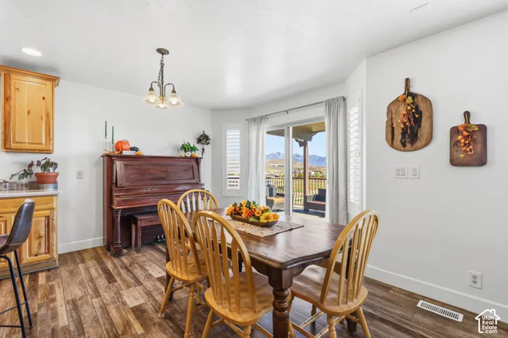 Wood-finish flooring, recessed lighting, and a chandelier with frosted glass shades