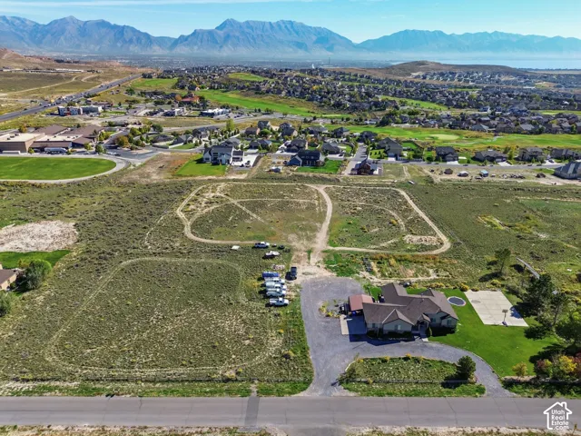 Expansive property featuring a single-story residence, asphalt driveway, basketball court, and manicured lawn