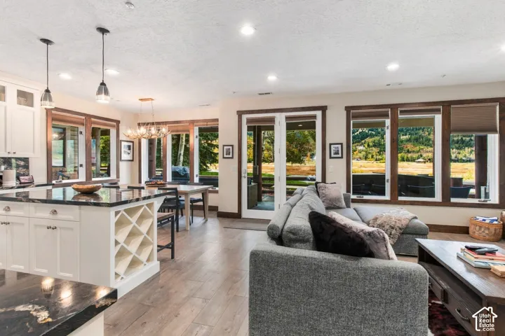Open-concept living space featuring wood-finish flooring, recessed lighting, and expansive windows with dark wood trim