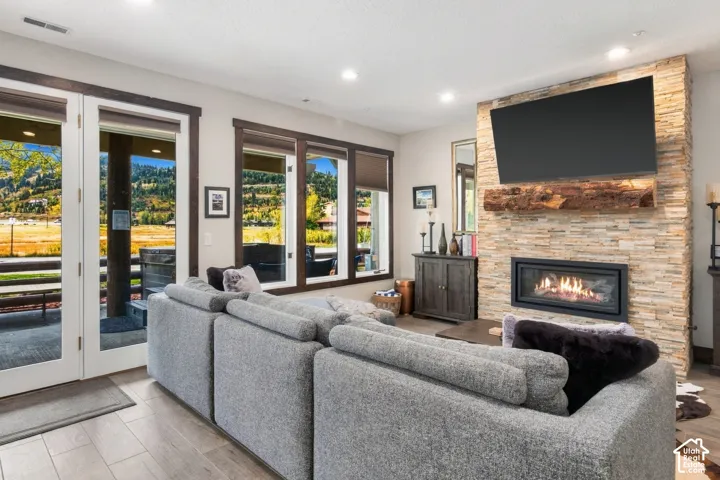 Stone-clad fireplace with a natural wood mantel, gas insert, and integrated media