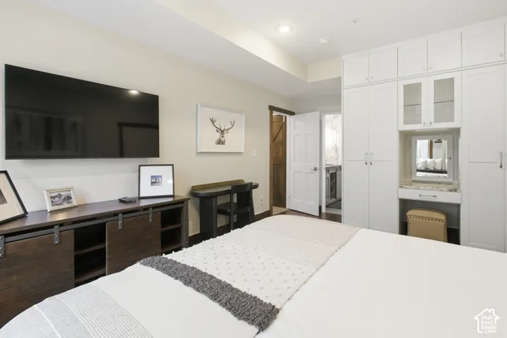 Built-in cabinetry with integrated vanity, wood-finish console with barn door sliders, and a solid core interior door